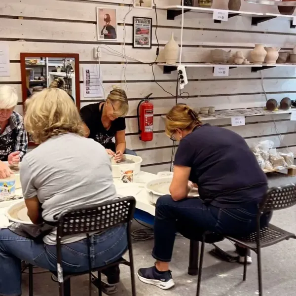 Grupp målar keramik i verkstaden